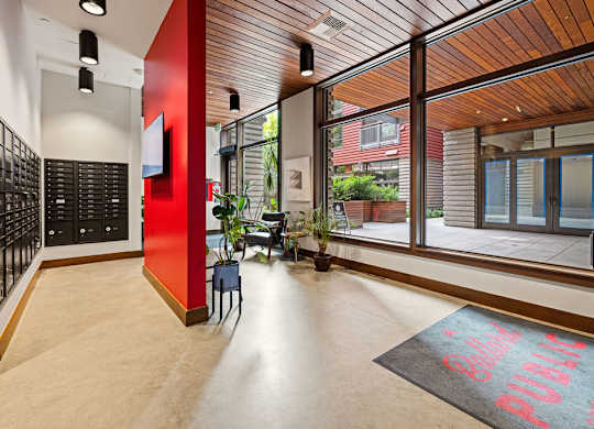 A hallway with a red wall and a black and white checkered floor.