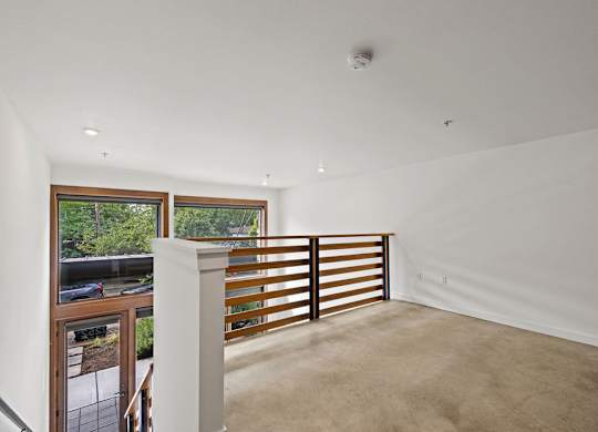 A white room with a window and a balcony.
