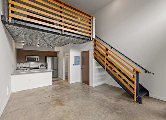 A modern kitchen with a wooden staircase.