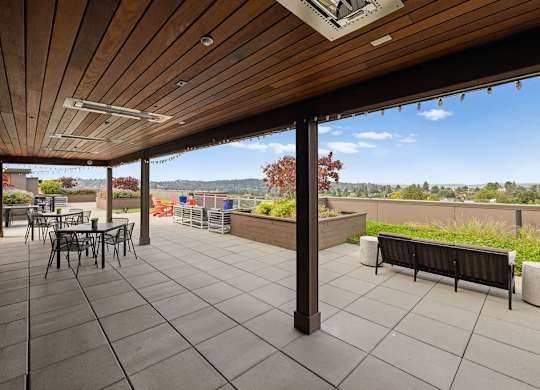 A patio with a table and chairs and a bench.