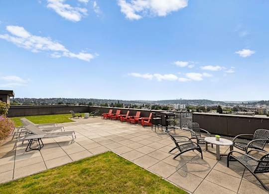 A patio with a table and chairs overlooking a city.