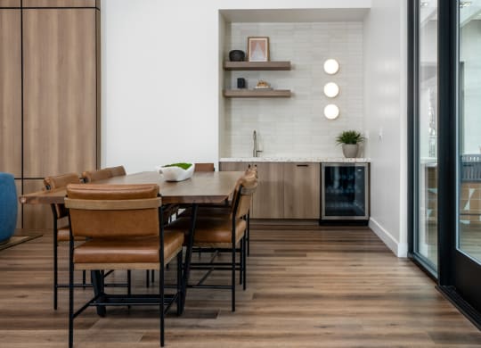 a dining room and kitchen with a wooden table and chairs