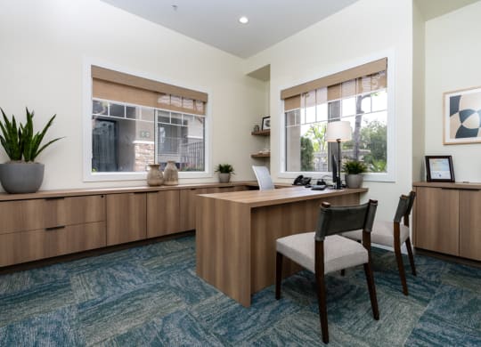 an office with a desk and chairs and a window