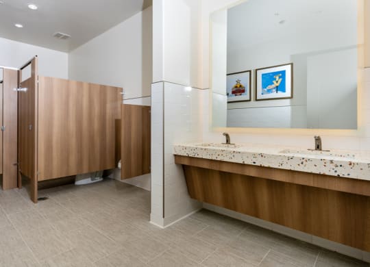 a public restroom with two stalls and two sinks and a mirror