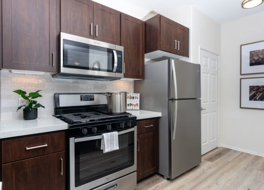1-Bedroom Apartments in Rancho Cucamonga, CA - Camino Real - Gourmet Kitchen with Stainless Steel Appliances, White Countertops, and Wood-Style Flooring