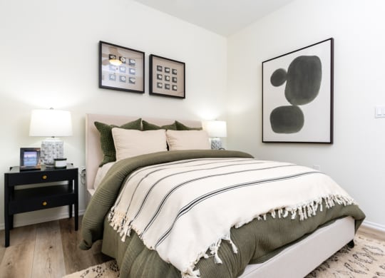 a bedroom with a bed and pictures on the wall