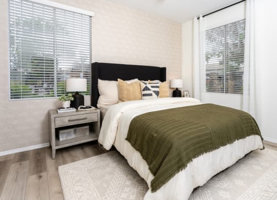 a bedroom with a bed and two windows