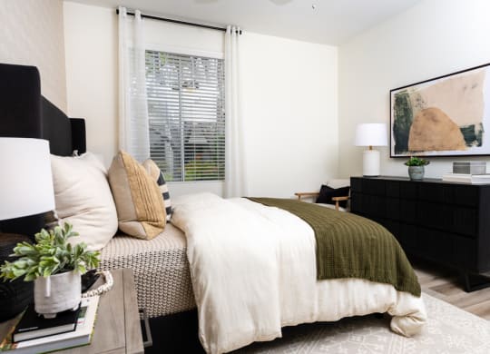 a bedroom with a bed and a dresser and a window