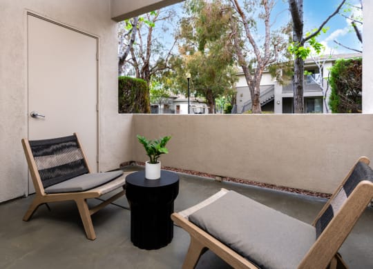 a balcony with two chairs and a table and a door