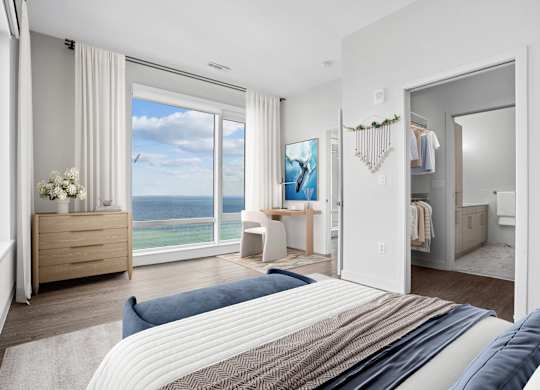 Second penthouse bedroom with a sliding glass door to the water, a desk nook, a spacious closet and a private bath.