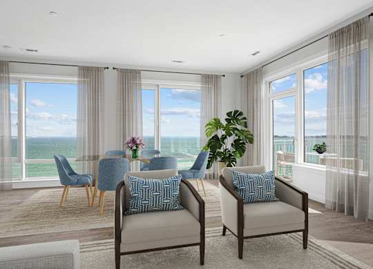 Penthouse dining area with a glass table, seating for four and windows on two walls looking out over the water.