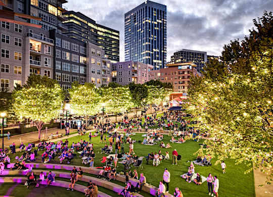 A large group of people are gathered in a park.