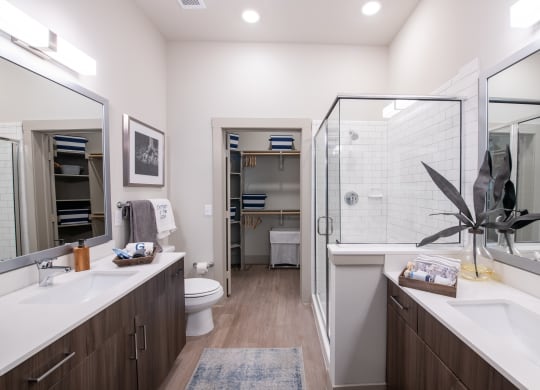 Double Vanity Bathroom with Frameless Glass Shower and Walk-In Closet