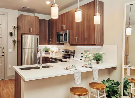 Island Kitchen with Sleek Dark Wood Cabinets and Undercabinet Lighting
