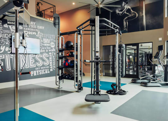 Open Gym Space with Cable Trainer, Punching Bag, and Cardio Machines