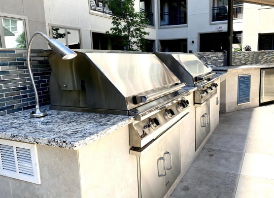 Stainless Steel Barbecue Grills with Tile Backsplash in Outdoor Kitchen