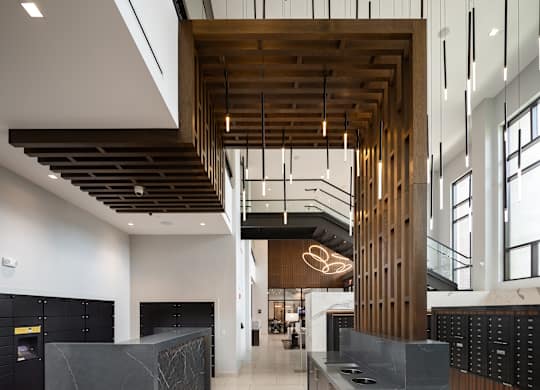 A modern office lobby with a wooden ceiling and black reception desks.