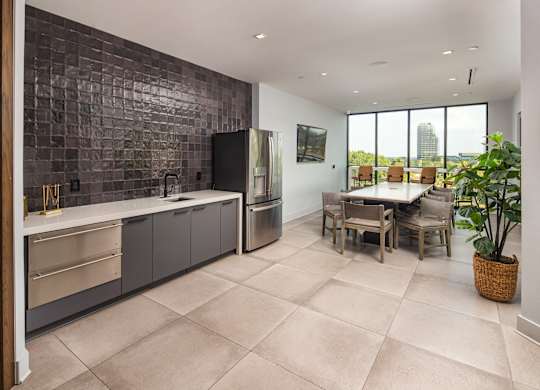 A kitchen with a tile backsplash and a dining table with chairs.
