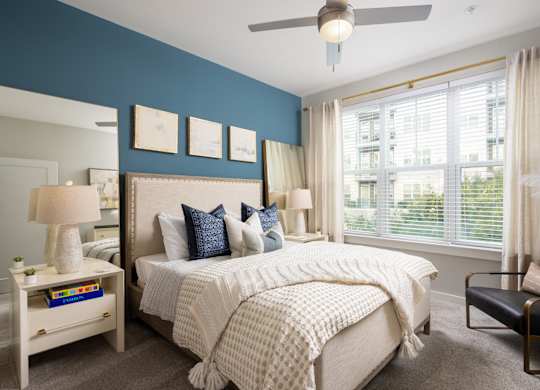 A bedroom with a large bed and a ceiling fan.