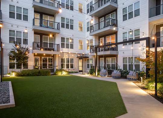 Apartment complex with a green lawn in front.