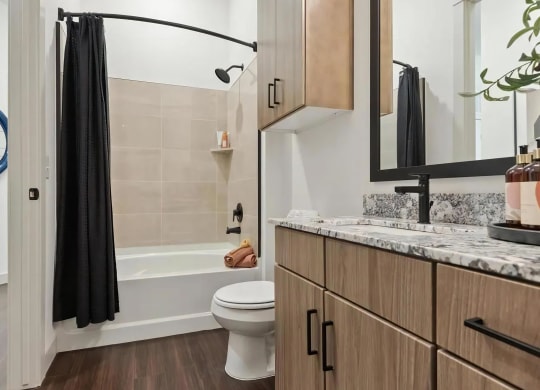 Bathroom with Wood Cabinets, Stone Countertops, and Shower-Tub Combo
