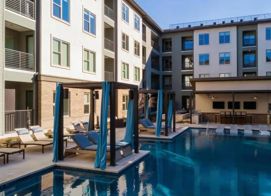 Poolside View of Clubhouse with Cabanas and Lounge Seating