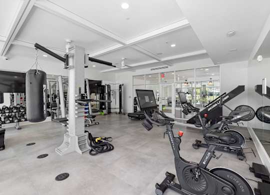 A gym with a variety of equipment including treadmills, weights, and exercise machines.