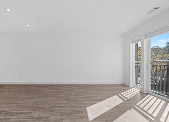 Expansive Living Room with Oversized Windows and Plank Flooring