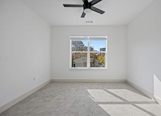 Tranquil Sleeping Space with Natural Light and Modern Fan