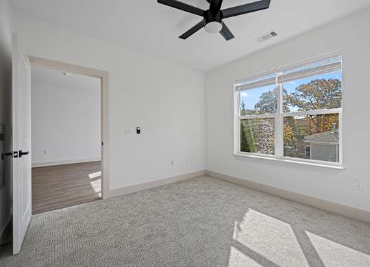 Spacious Bedroom with Ceiling Fan and Connecting Room Access