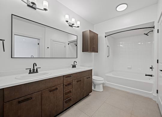 Spacious Bathroom Featuring Dual Sinks and Shower/Tub Combo