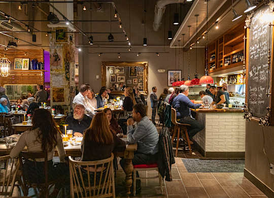 A group of people are sitting at tables in a restaurant.