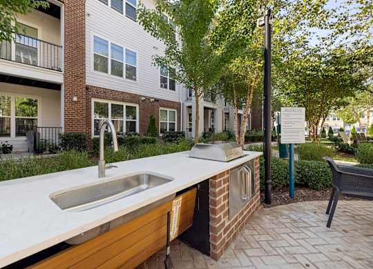 A modern outdoor kitchen with a sink and grill.