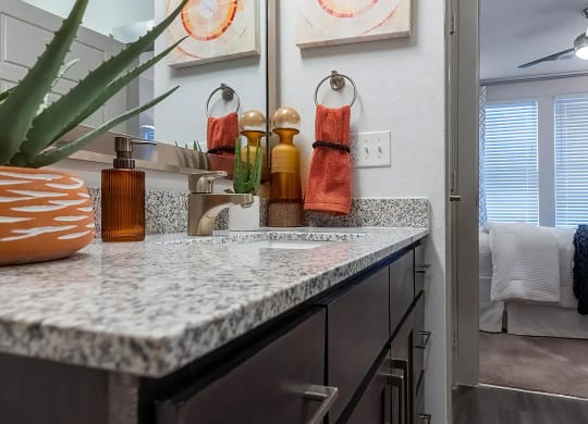 Dual Vanities With Granite Countertops and Bedroom Access