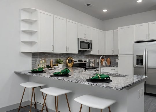 Open Kitchen Layout with White Cabinets and Stainless Steel Appliances