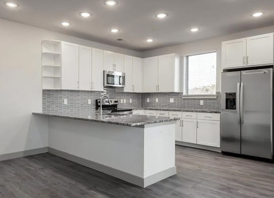 Modern Kitchen with Oversized Granite Breakfast Bar and Ample Storage