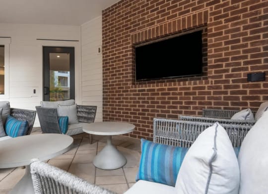 Cozy Outdoor Seating Area with Mounted TV and Modern Furniture