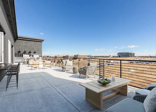 a rooftop terrace with furniture and a view of the city