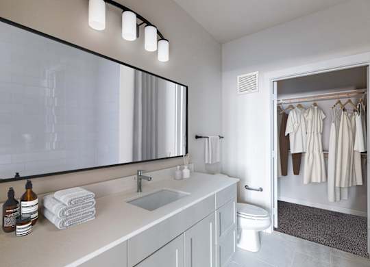 a bathroom with a large mirror and a sink and a toilet