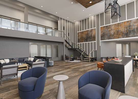 a lobby with couches and chairs and a staircase