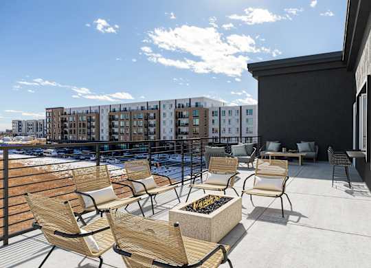 the deck of a building with chairs and a fire pit