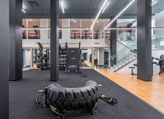 A gym with a variety of equipment including a tire flipping station.