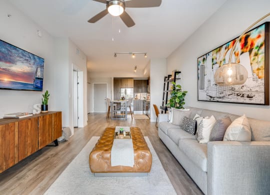 Living Room with Wall-Mounted TV and Entry to Kitchen and Dining Space