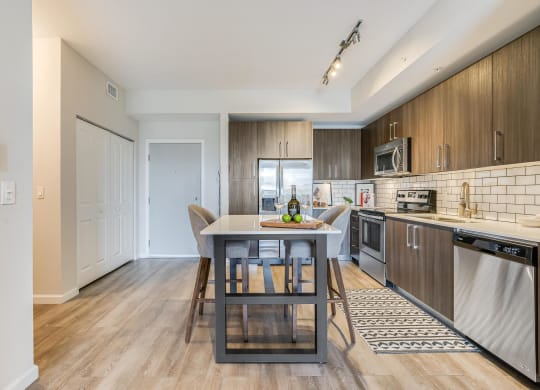 Full Kitchen with Dining Island, Stainless Steel Appliances, and Tile Backsplash