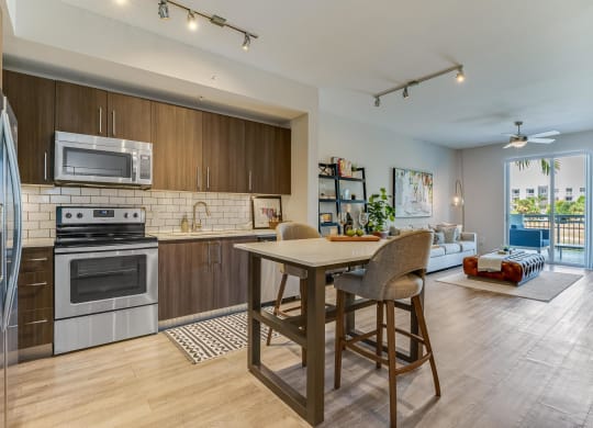 Kitchen and Living Room View with Island and Private Balcony Access