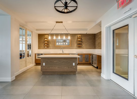 Open Kitchenette with Wall Shelving, Island Counter, and Wine Fridge