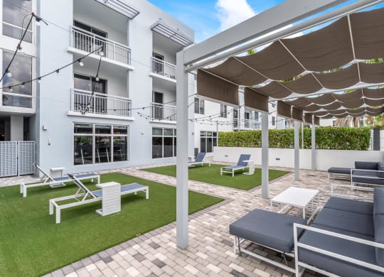 Ground-Level Green Space with Lounge Chairs and Walkways Next to Residential Windows