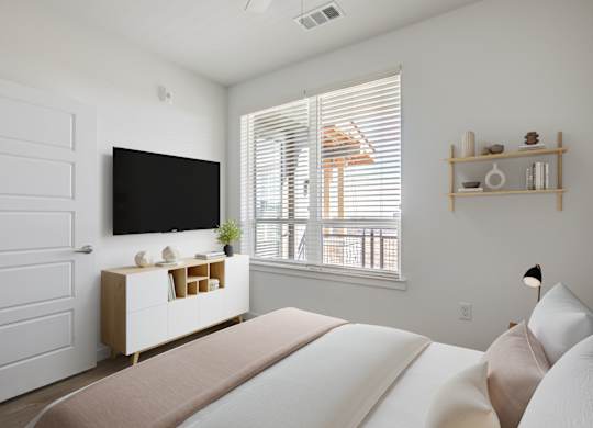a bedroom with a large bed and a tv on the wall
