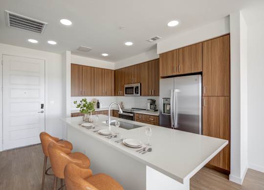 a kitchen with a white counter top and wooden cabinets