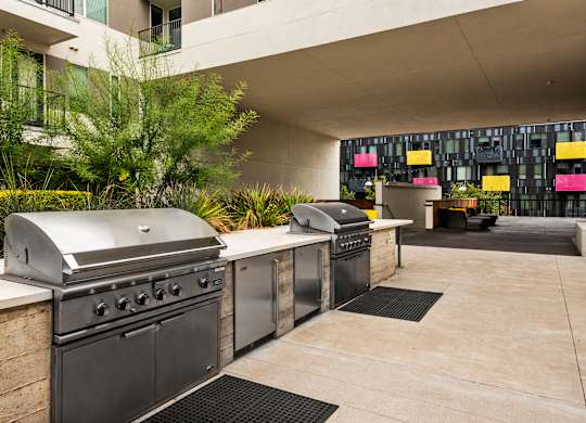 A modern outdoor kitchen with a grill and sink.